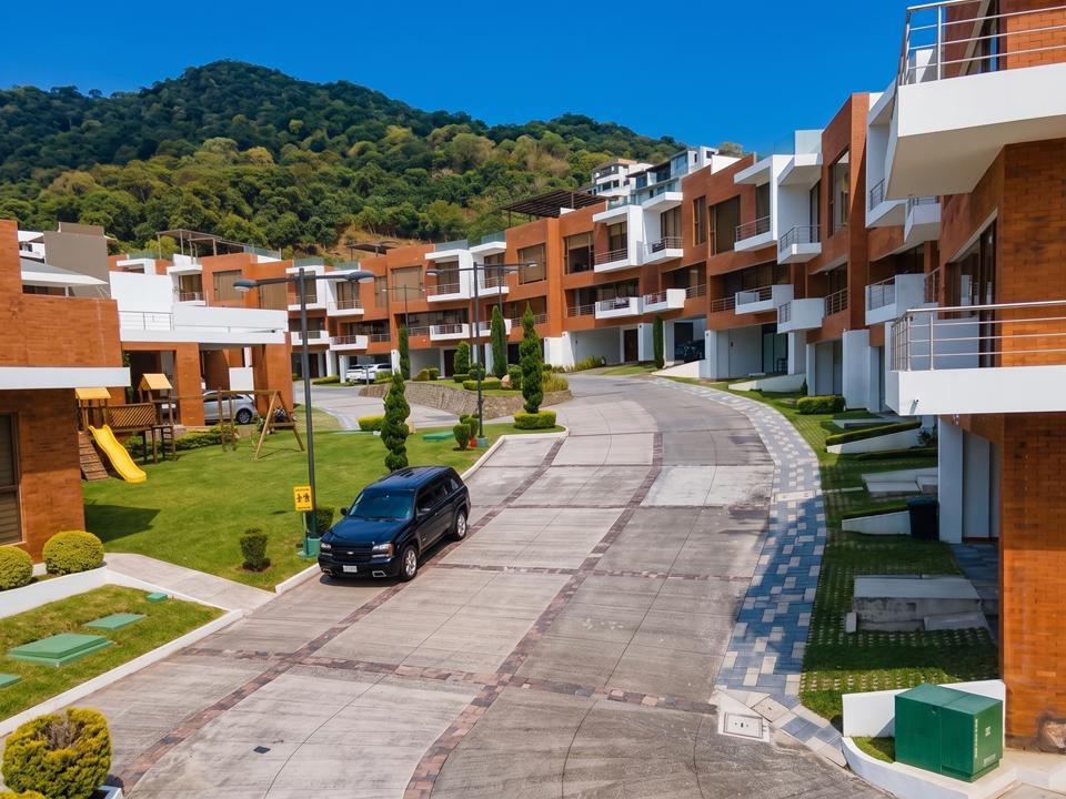 Calle interior del residencial con casas y áreas verdes